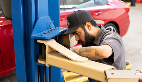 Advanced Air & Vacuum technician servicing an automotive shop lift for professional vehicle service equipment maintenance.