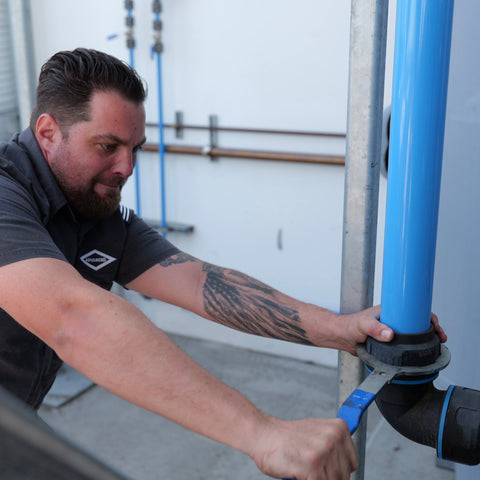 Technician installing compressed air piping system for industrial facility in Southern California and Arizona