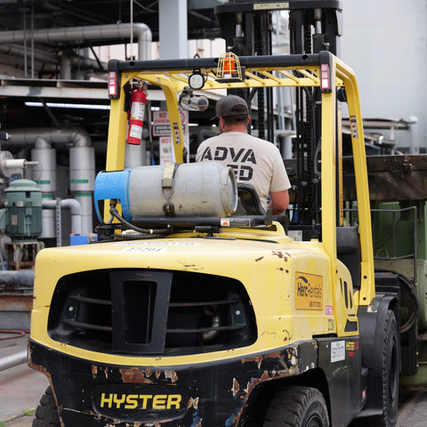 Technician positioning compressed air equipment with forklift during installation process