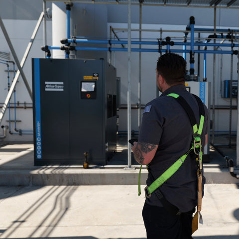 Technician installing industrial compressed air system, during installation