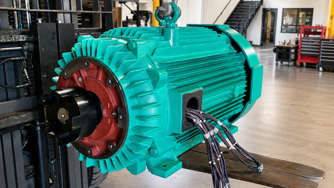Large industrial electric motor being repaired and rebuilt inside the Advanced Air & Vacuum motor shop.